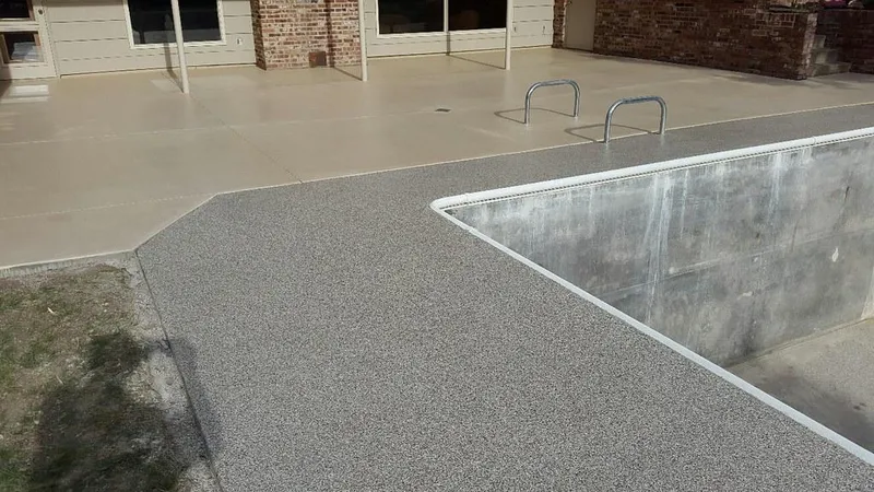 Coated concrete deck next to an empty pool